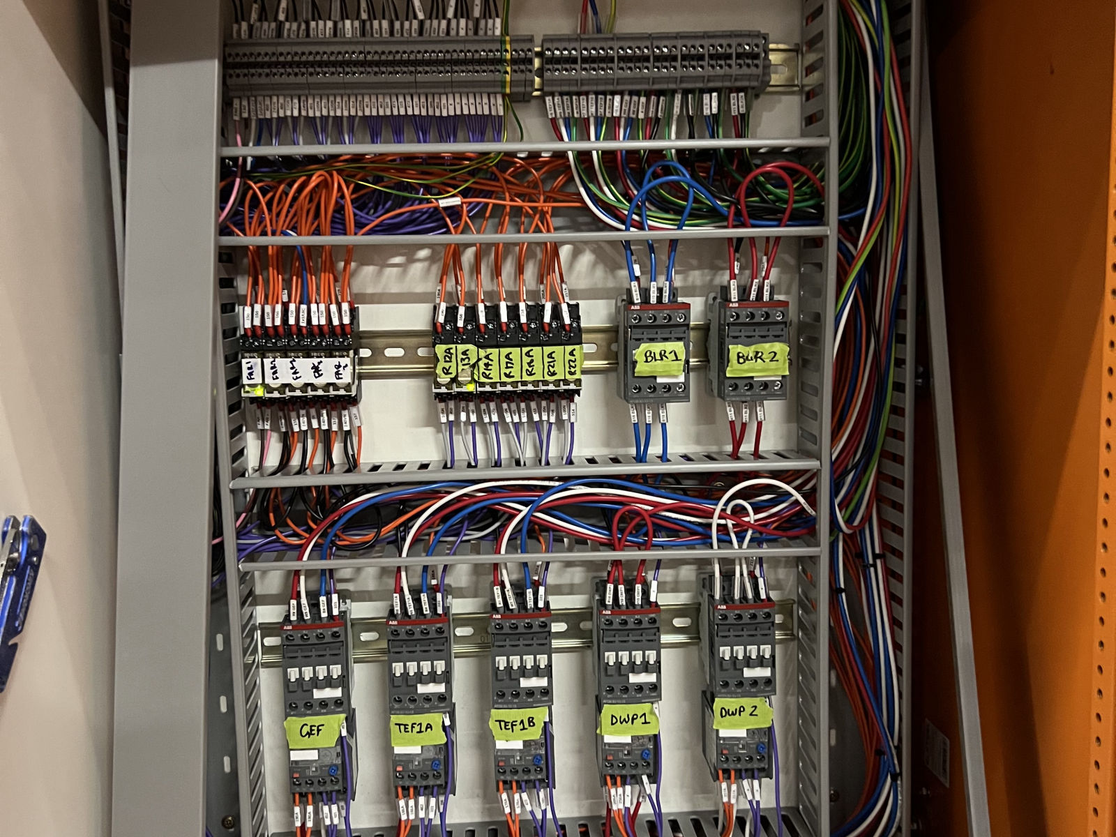 Motor control panel being built, showing labelled contactors, relay banks and terminal rails